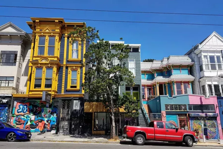 Vista de edificios coloridos en Haight Street con autos estacionados a lo largo de la calle. San Francisco, California.